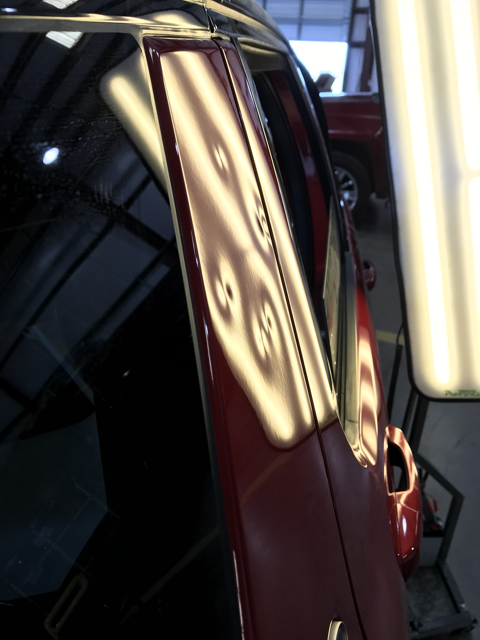 Red SUV pillar dents before repair